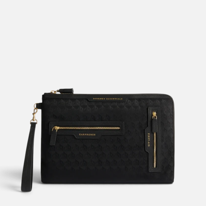 Shop Rescue Spa black nylon Journey Essentials travel pouch with gold zippers and labelled external pockets.