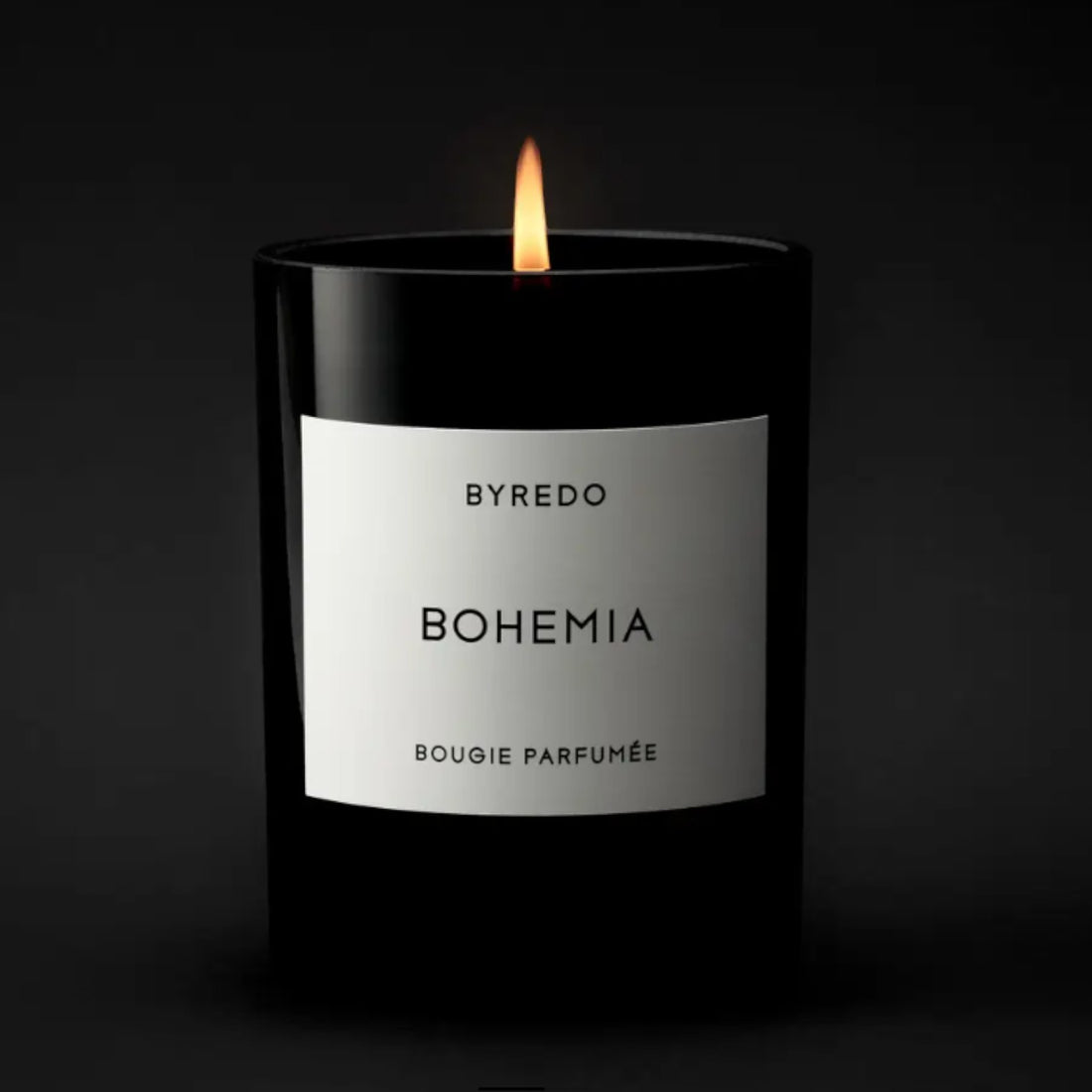 Shop Rescue Spa Bohemia scented candle in a black glass jar with a white label, burning with a warm flame.