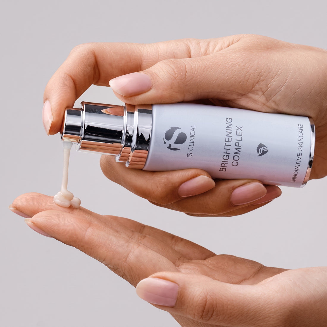 Shop Rescue Spa iS Clinical Brightening Complex serum being dispensed onto a hand for skin tone improvement