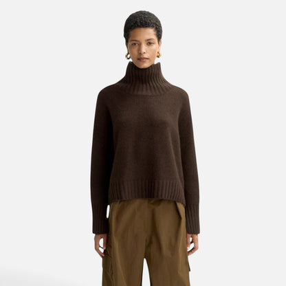 Model wearing a Shop Rescue Spa chunky dark brown cashmere turtleneck sweater with sleeve slits