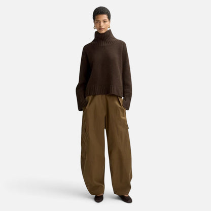 Model wearing a Shop Rescue Spa dark brown chunky cashmere turtleneck sweater with sleeve slits and relaxed fit