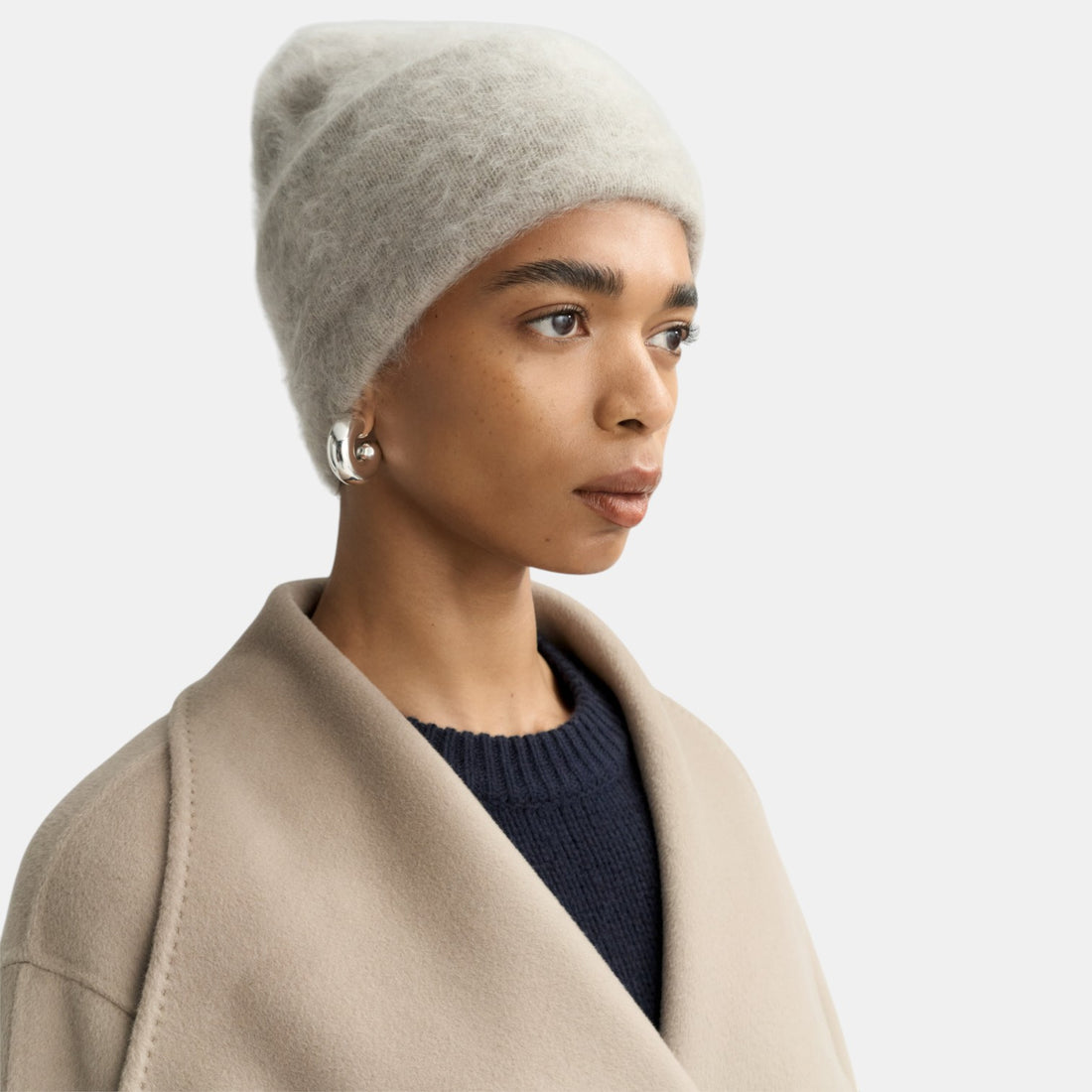 Shop Rescue Spa brushed cashmere beanie in light grey worn by a model in a neutral coat