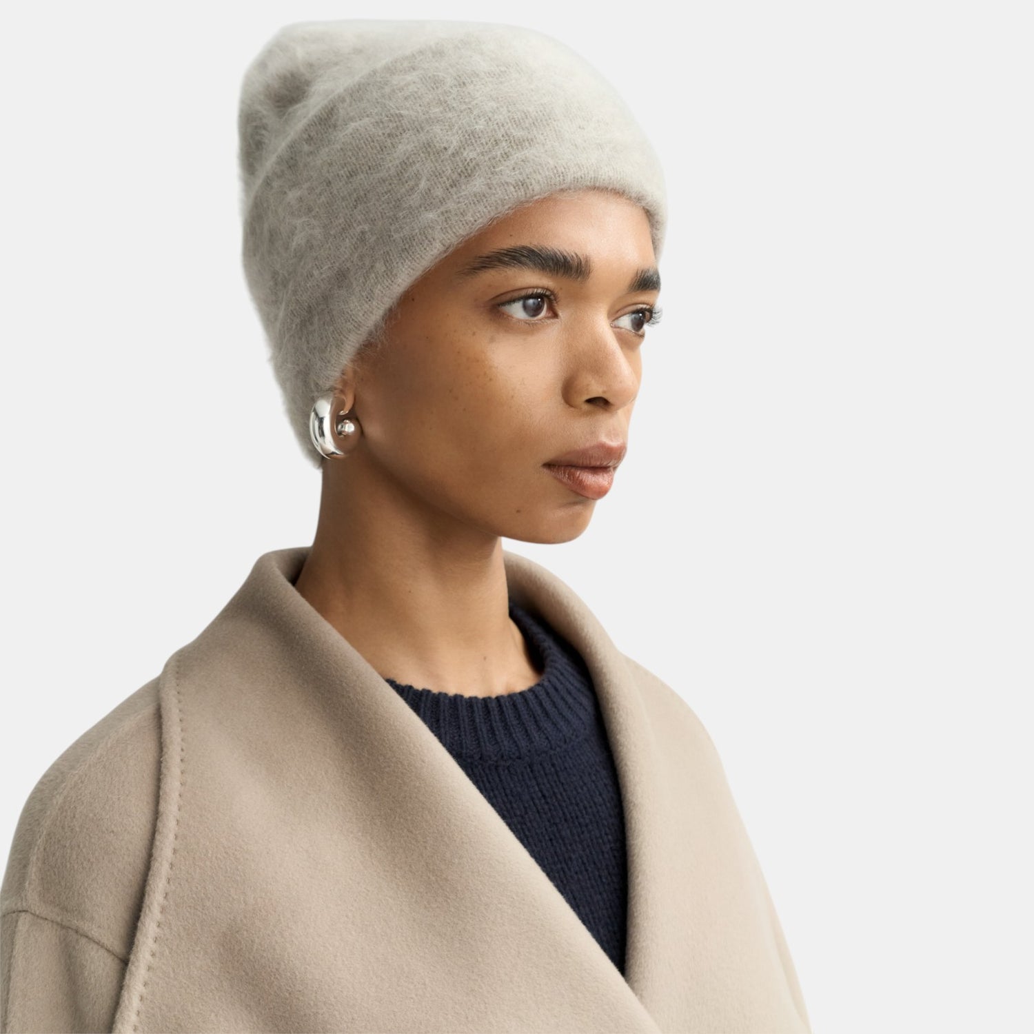 Shop Rescue Spa brushed cashmere beanie in light grey worn by a model in a neutral coat