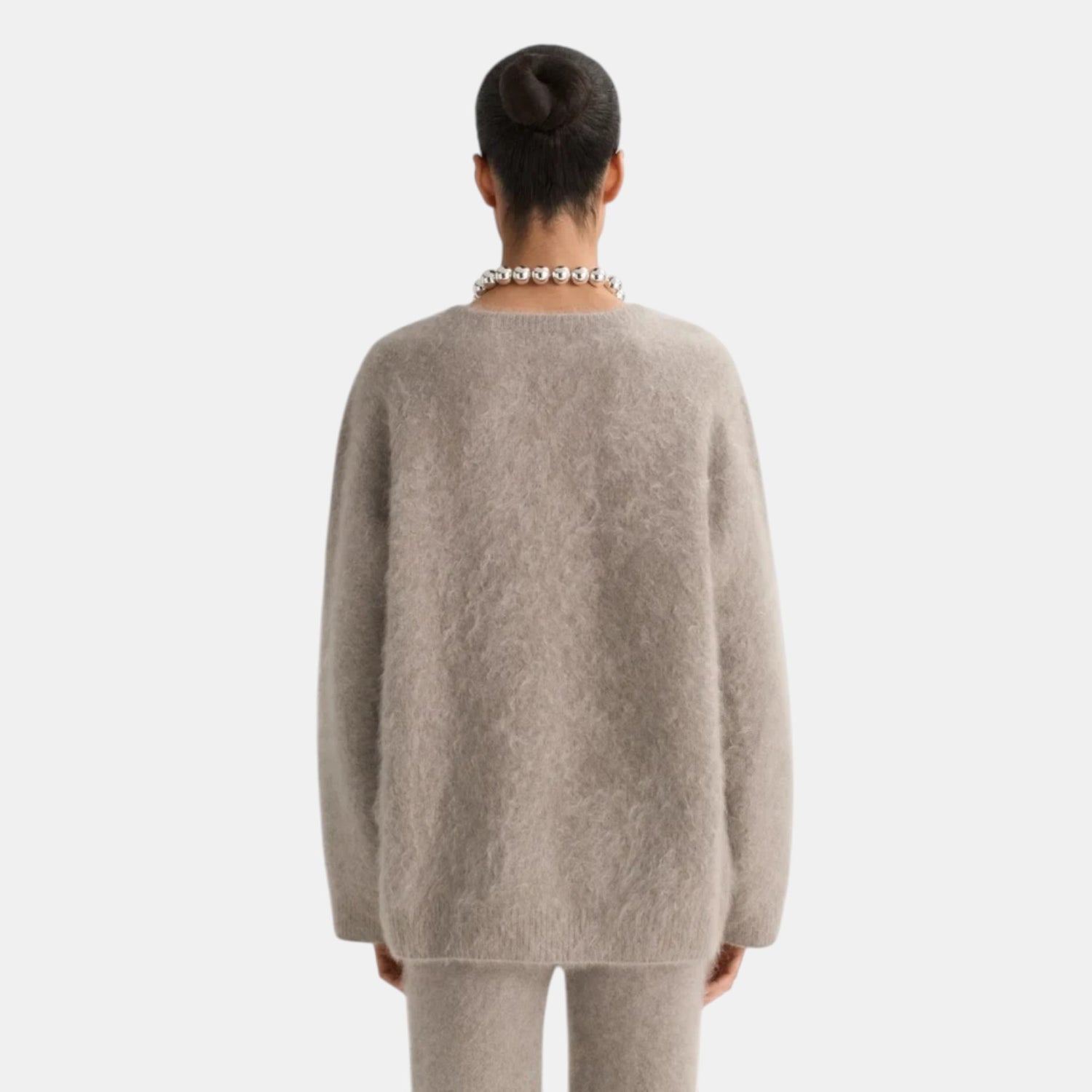 Back view of Shop Rescue Spa brushed cashmere v-neck sweater in beige, featuring a soft knit texture.