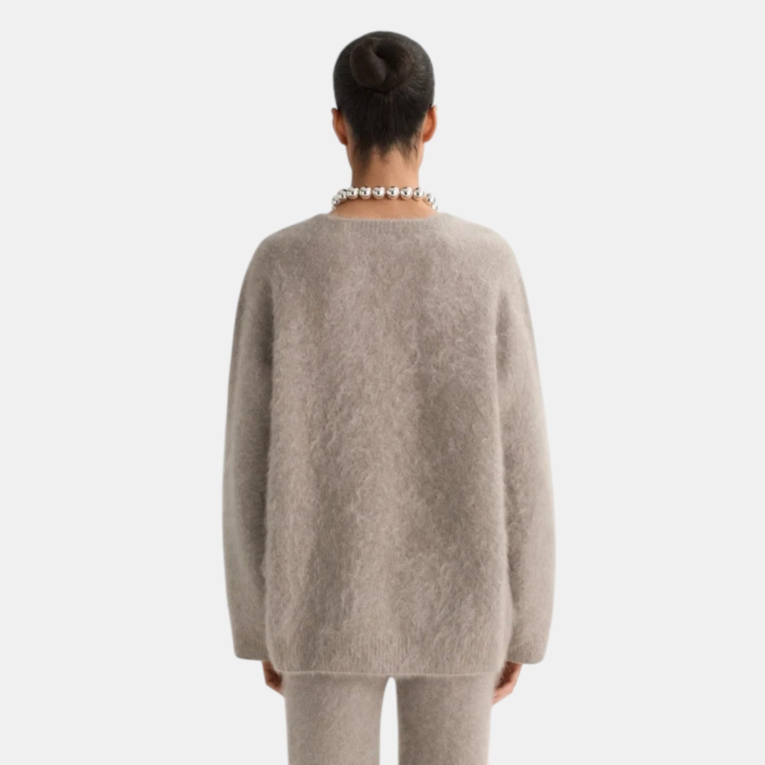 Back view of Shop Rescue Spa brushed cashmere v-neck sweater in beige, featuring a soft knit texture.
