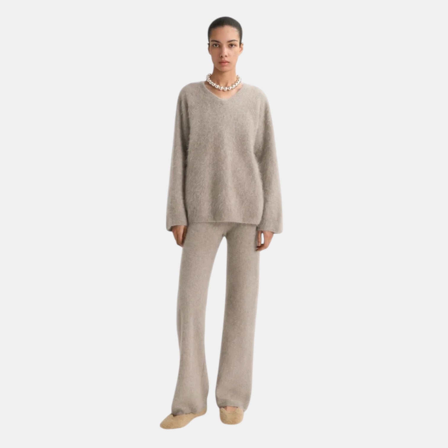 Model wearing a Shop Rescue Spa brushed cashmere v-neck sweater and matching lounge pants in beige