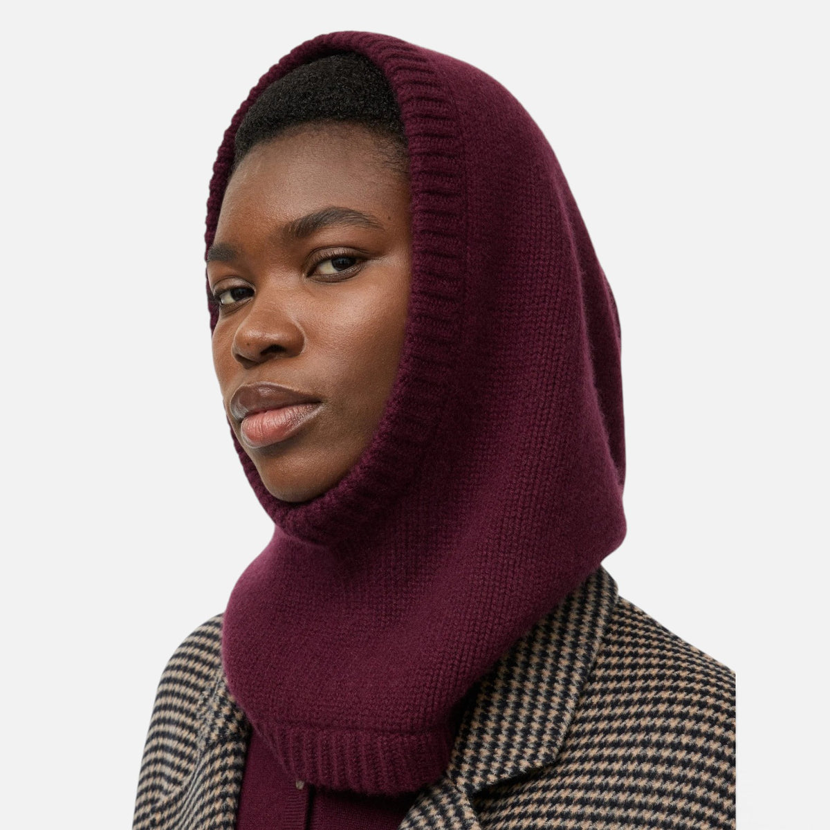 Shop Rescue Spa chunky knit balaclava in deep burgundy 100% cashmere worn by a model in a plaid coat