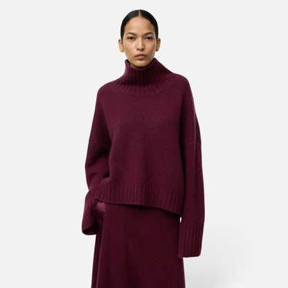 Shop Rescue Spa burgundy chunky cashmere turtleneck sweater with sleeve slits worn by a model
