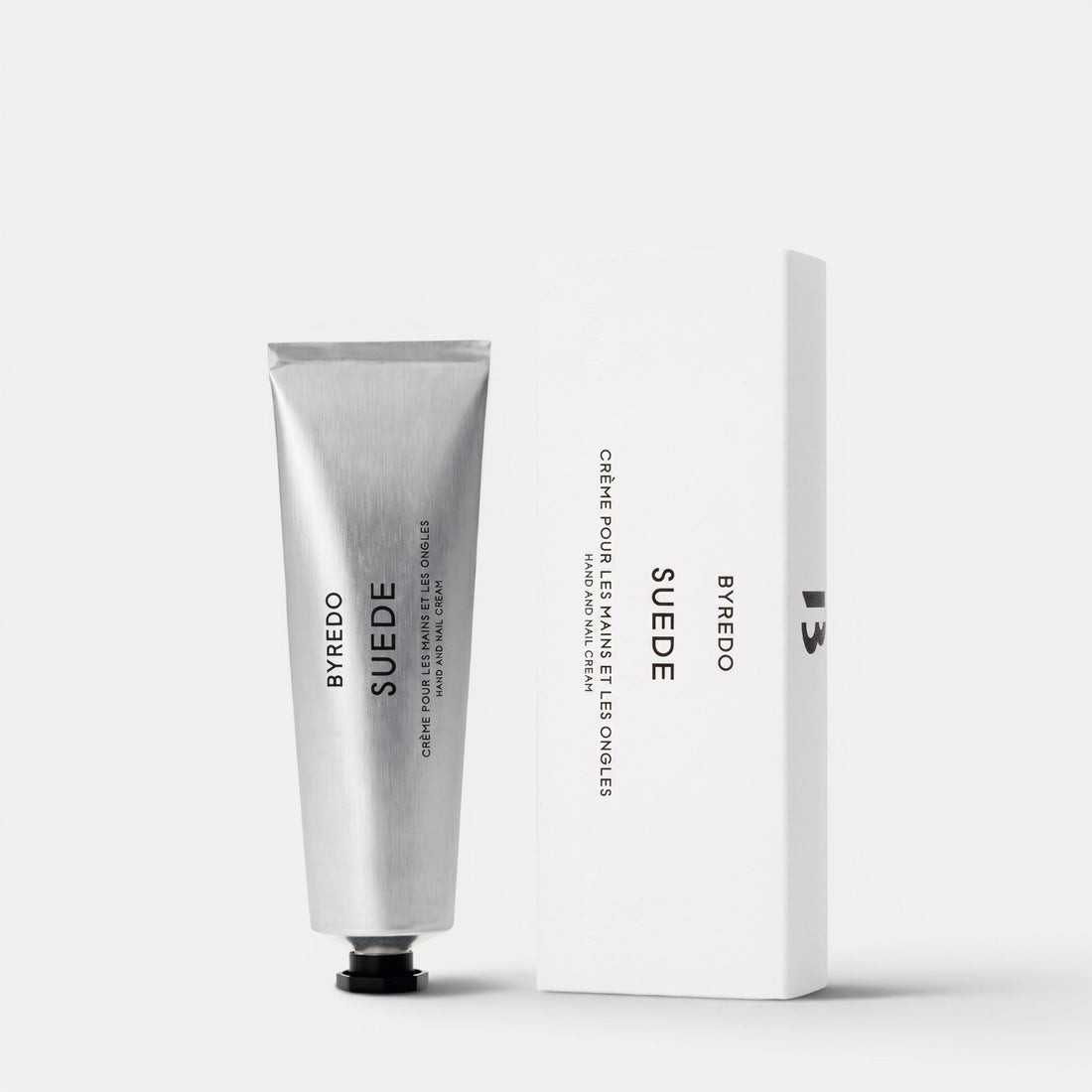 Shop Rescue Spa Byredo Suede hand and nail cream in a silver tube next to its white minimalist product box.