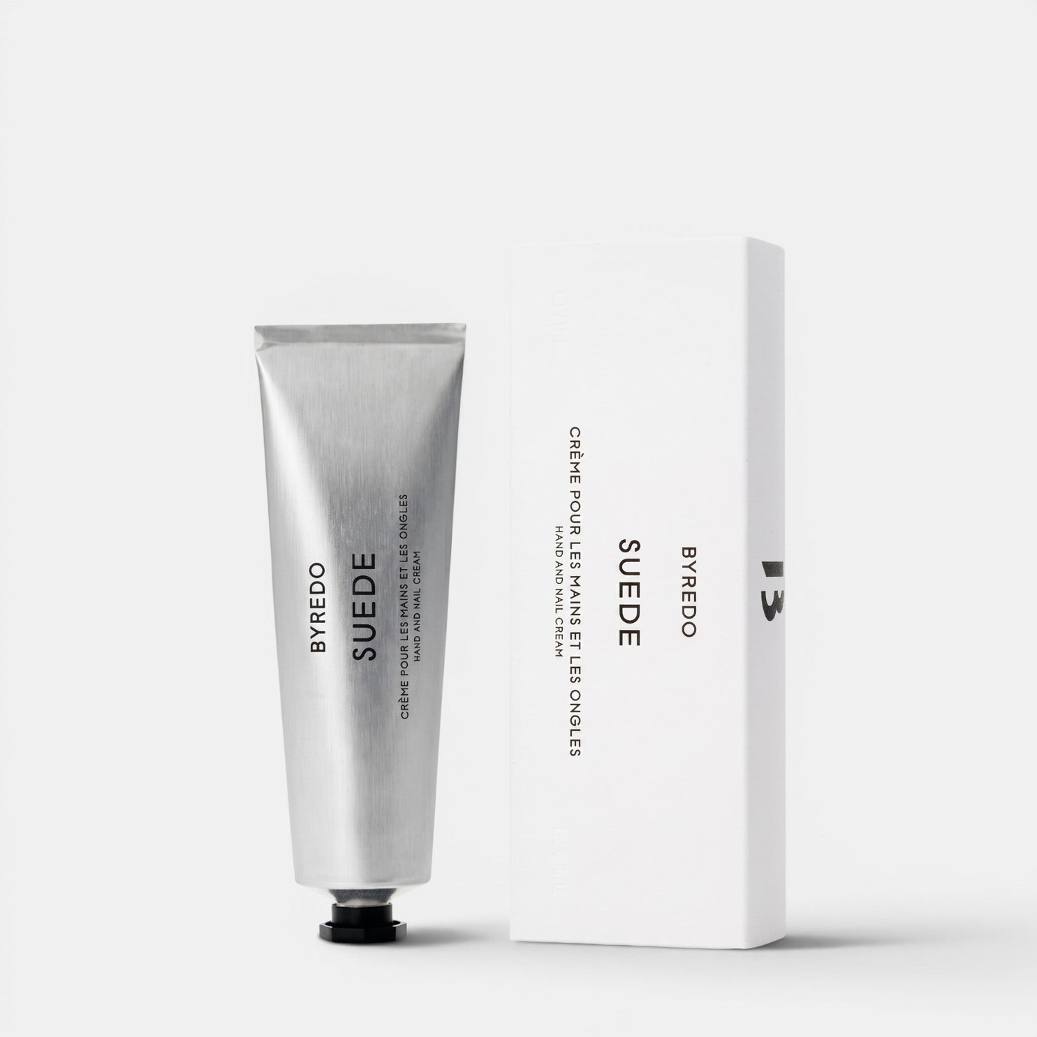 Shop Rescue Spa Byredo Suede hand and nail cream in a silver tube next to its white minimalist product box.