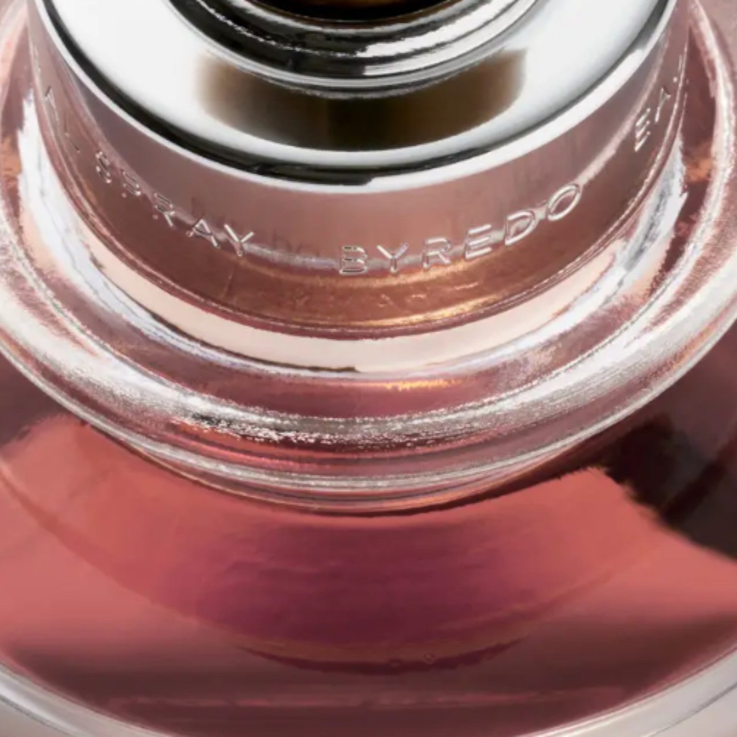 Shop Rescue Spa Casablanca Lily Extrait De Parfum, a rose-gold liquid in a glass bottle with a silver cap engraved with &