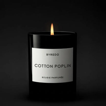 Shop Rescue Spa Cotton Poplin candle in a black glass jar with a white label, lit flame.