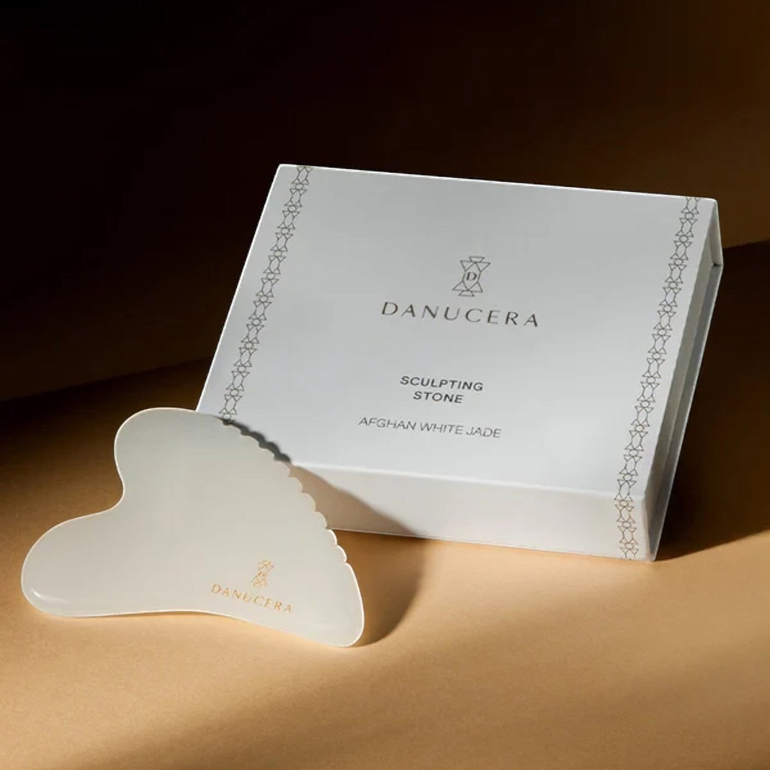 Shop Rescue Spa DANUCERA Sculpting Stone made of white jade for facial massage, shown with its branded gift box.