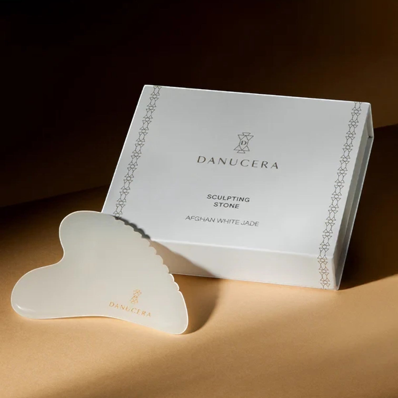 Shop Rescue Spa DANUCERA Sculpting Stone made of white jade for facial massage, shown with its branded gift box.