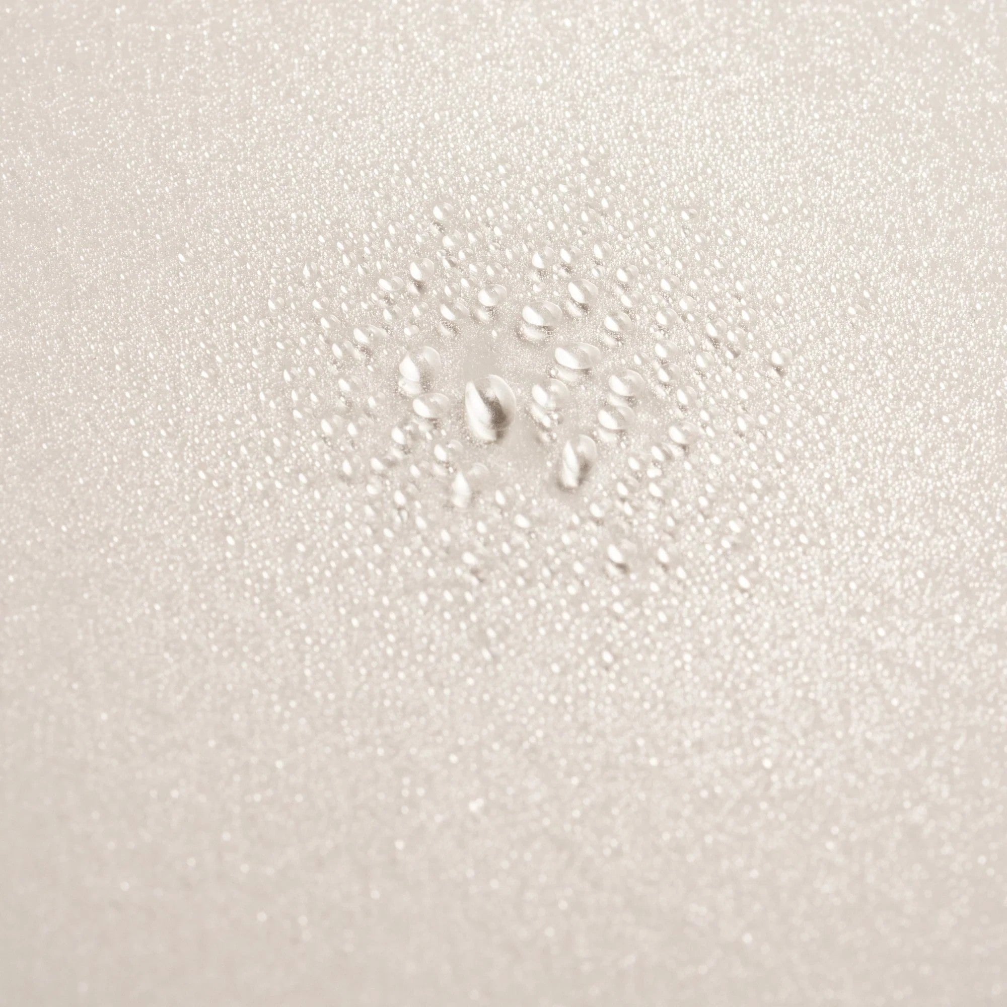 Shop Rescue Spa Serene Scalp Densifying Treatment Spray with water droplets on a textured beige surface