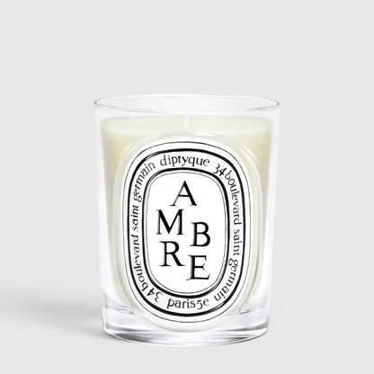 Shop Rescue Spa Diptyque Ambre scented candle in a clear glass vessel with a signature oval label