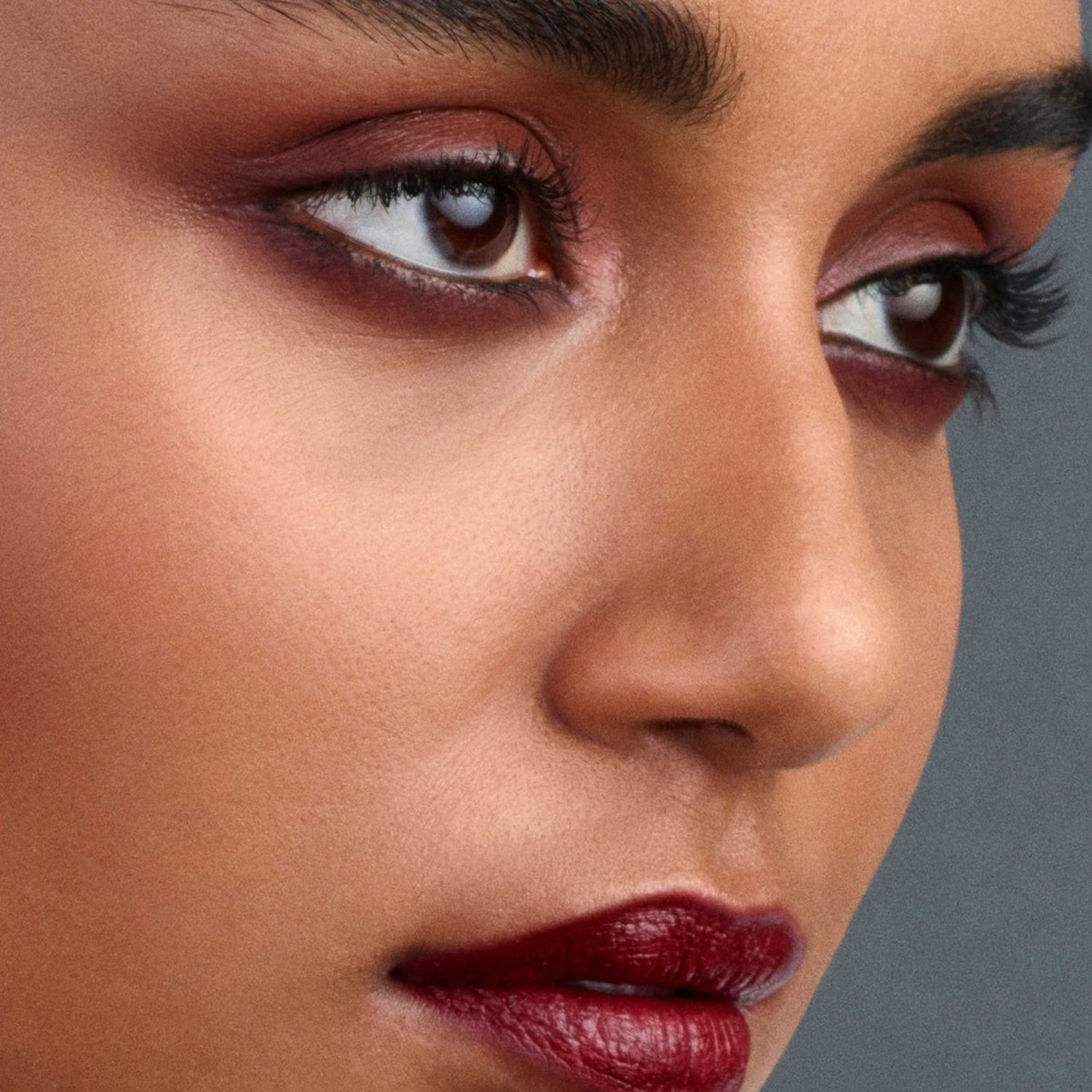 Shop Rescue Spa Eye Pods Les Nuits eyeshadow trio applied on a model with deep red and champagne tones for a luminous finish