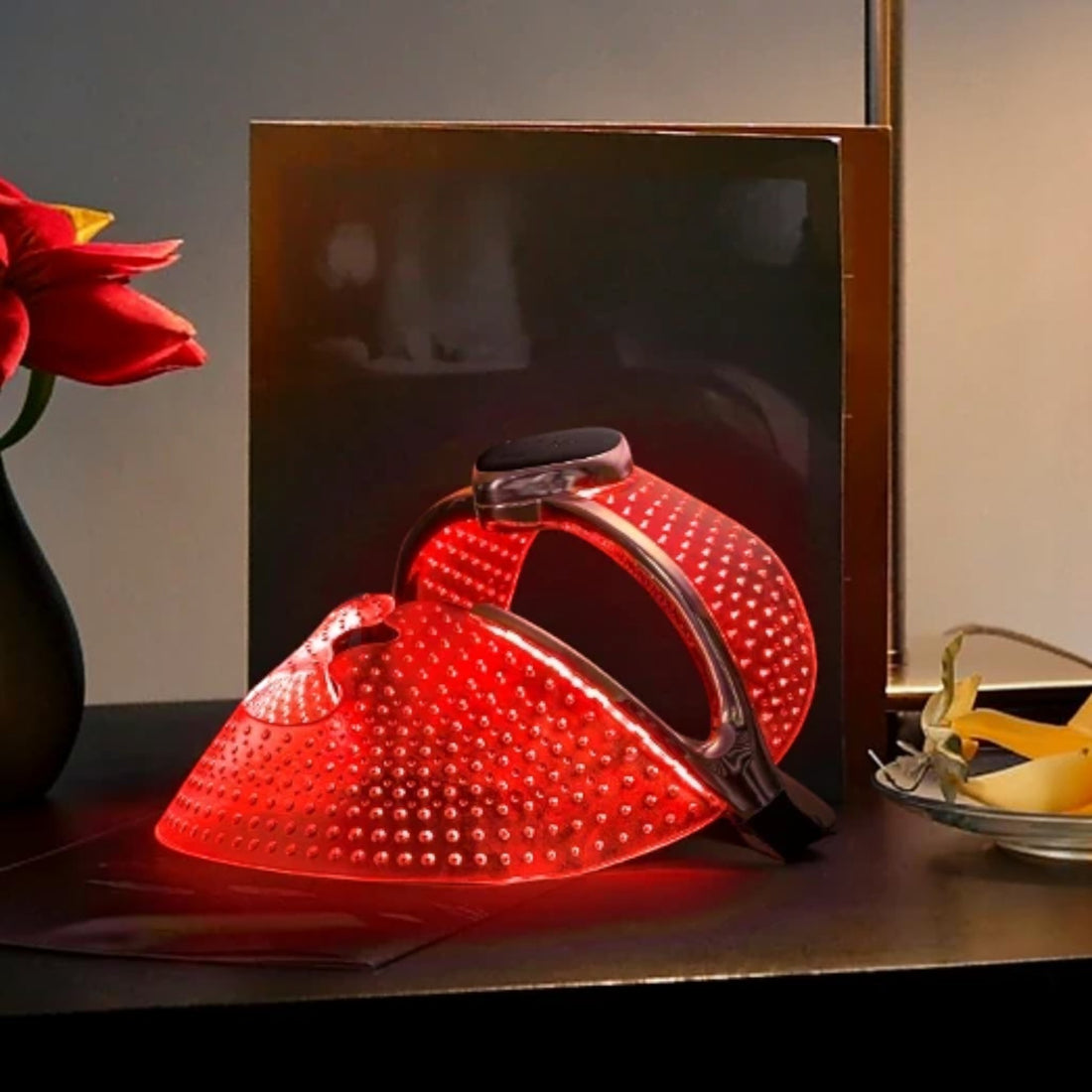 Shop Rescue Spa FAQ 202 anti-aging silicone LED face mask glowing with red light therapy on a dark surface