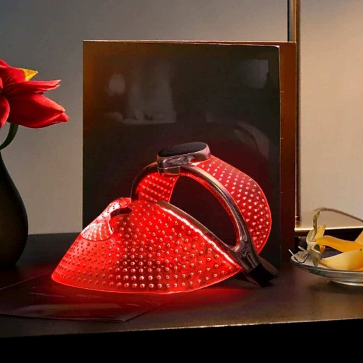 Shop Rescue Spa FAQ 202 anti-aging silicone LED face mask glowing with red light therapy on a dark surface