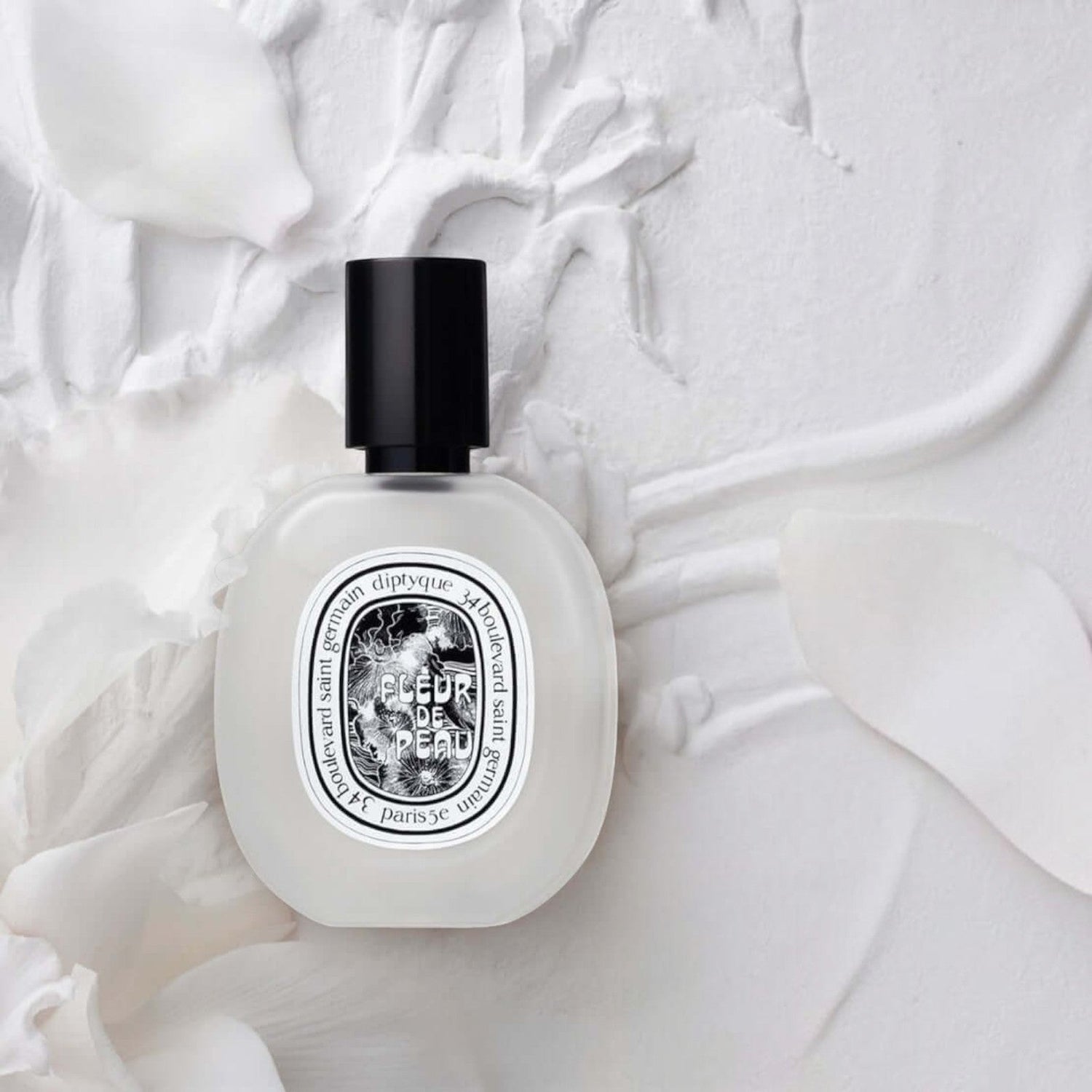 Shop Rescue Spa Fleur De Peau hair mist in a frosted glass bottle with a black cap on a white floral background