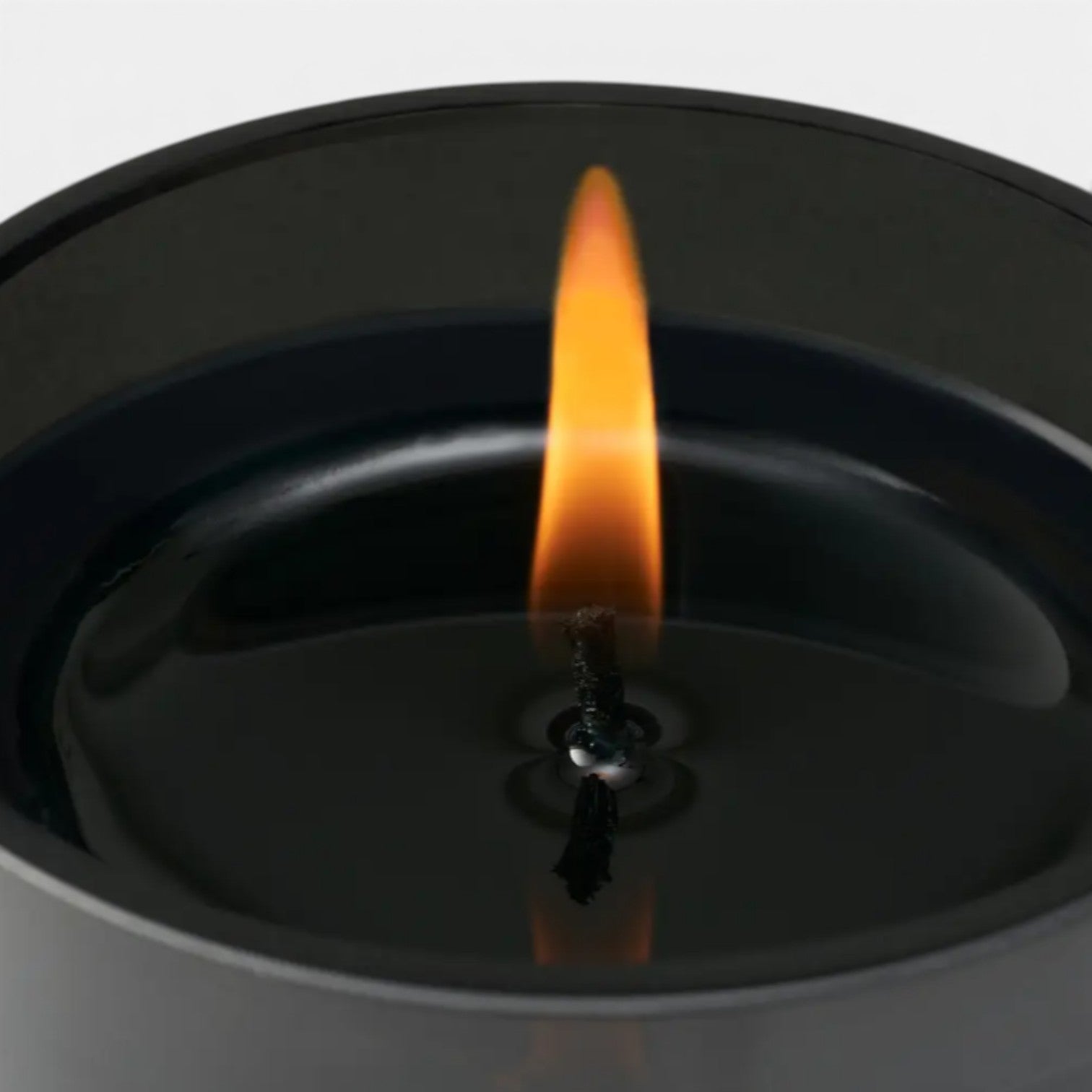 Shop Rescue Spa Fleur Fantome black candle with a lit wick, featuring heliotrope and suede notes.