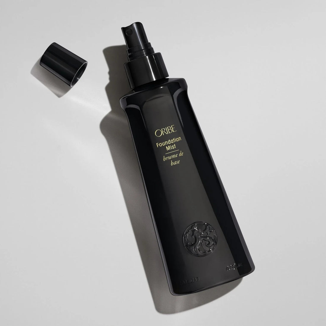 Shop Rescue Spa ORIBE Foundation Mist hair primer spray for shine, detangling, and heat protection. Black bottle with gold lettering.