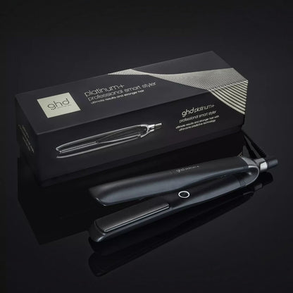 Shop Rescue Spa ghd Platinum+ smart flat iron with its black branded packaging box on a reflective dark surface