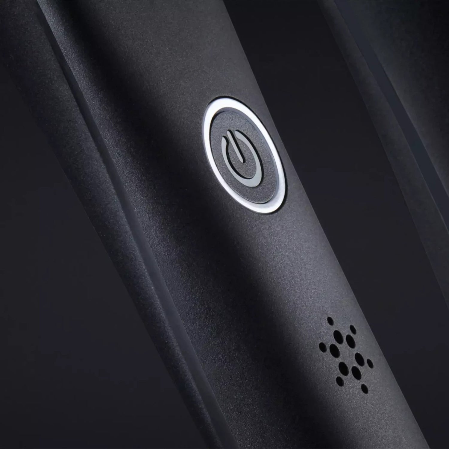 Close-up of the Shop Rescue Spa ghd Platinum+ Styler power button and indicator light on a matte black handle.