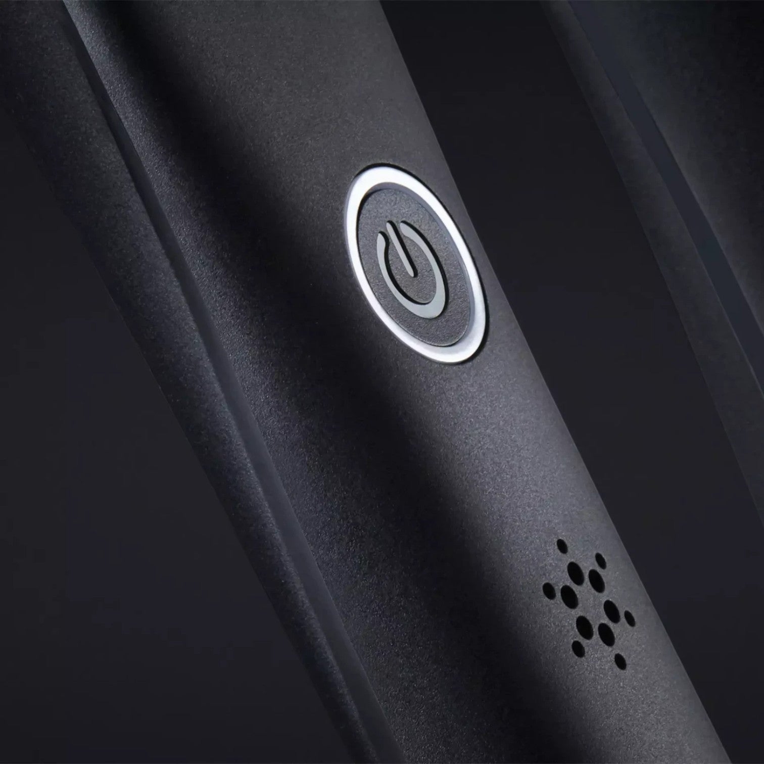 Close-up of the Shop Rescue Spa ghd Platinum+ Styler power button and indicator light on a matte black handle.
