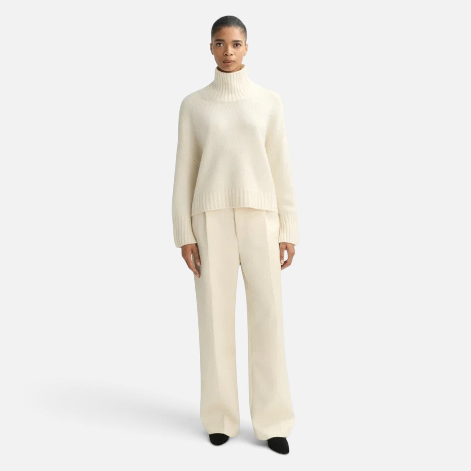 Shop Rescue Spa Girlfriend Turtleneck in cream 100% cashmere with chunky knit and sleeve slits on a model
