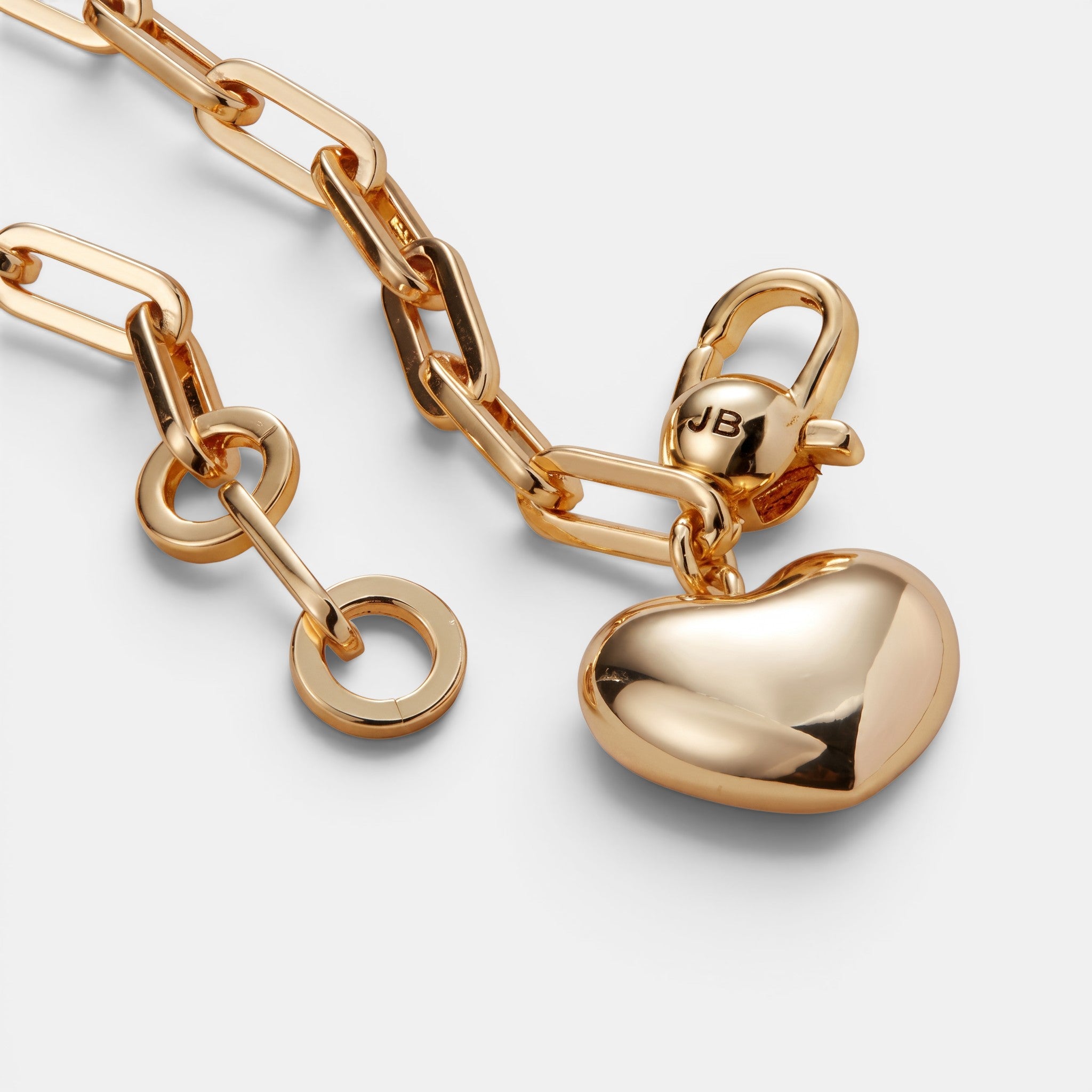 Shop Rescue Spa gold puffy heart charm bracelet on a polished paperclip link chain against a white background.