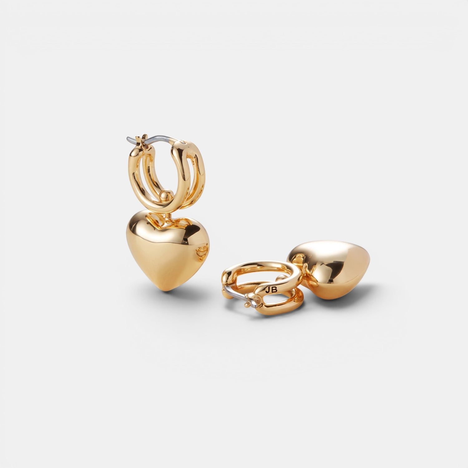 Shop Rescue Spa high-polish gold huggie earrings featuring a sliding puffy heart charm on a golden rail.