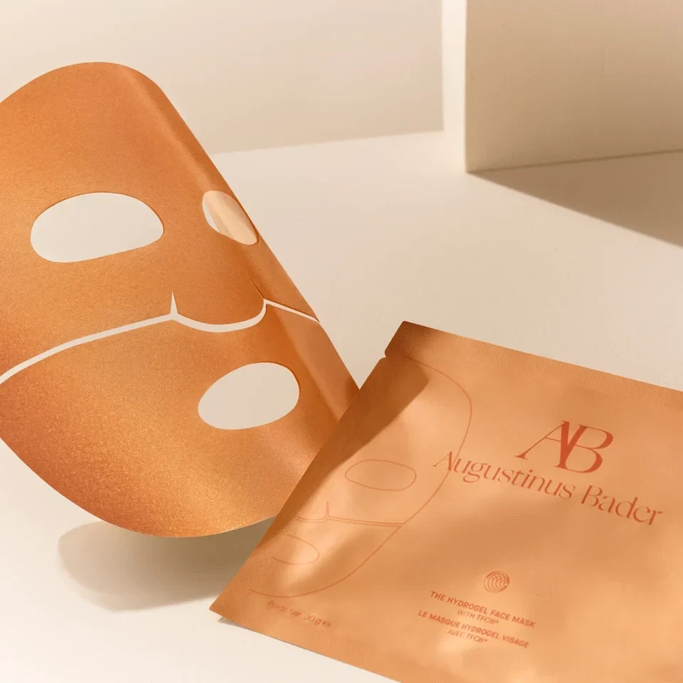 Shop Rescue Spa Augustinus Bader hydrogel face mask sheet and metallic gold packaging on a neutral background