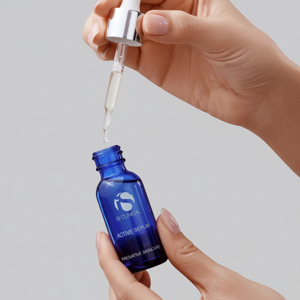 Shop Rescue Spa iS Clinical Active Serum in a blue glass bottle with a dropper being held by a person