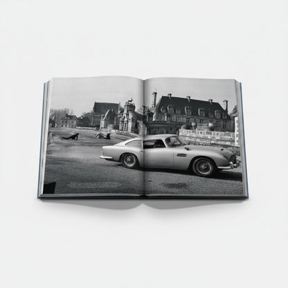 James Bond Cars book featuring an Aston Martin DB5 in a black and white scene with a chateau in the background.
