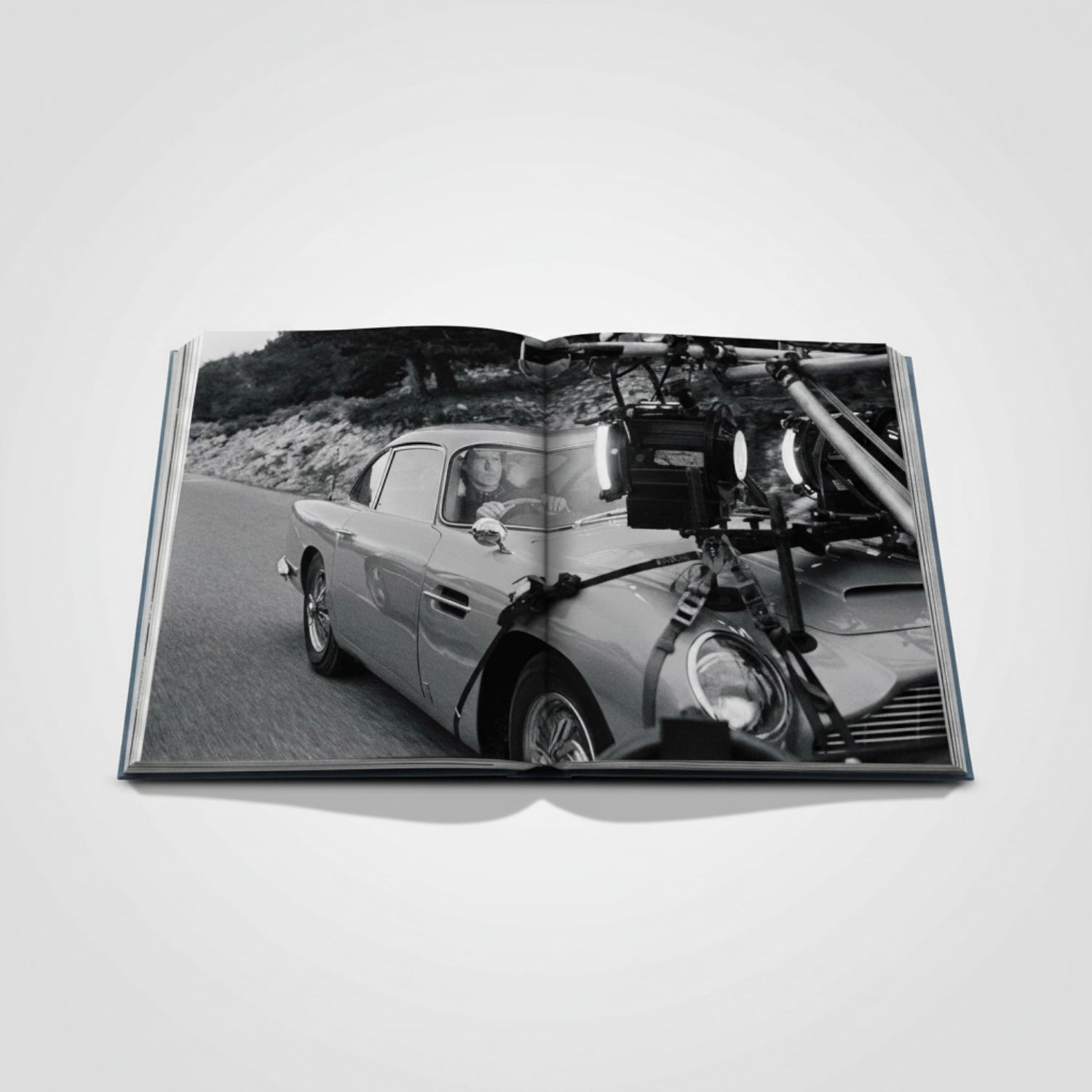 Shop Rescue Spa James Bond Cars book features an Aston Martin DB5 on a scenic road, with film equipment attached.