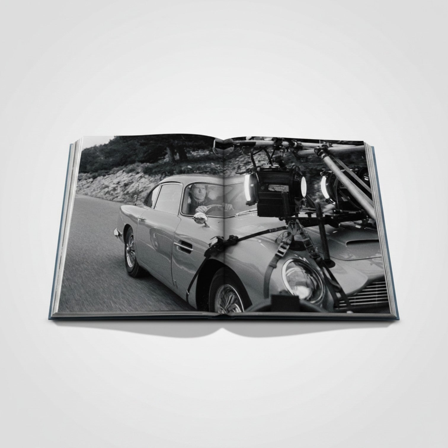 Shop Rescue Spa James Bond Cars book features an Aston Martin DB5 on a scenic road, with film equipment attached.