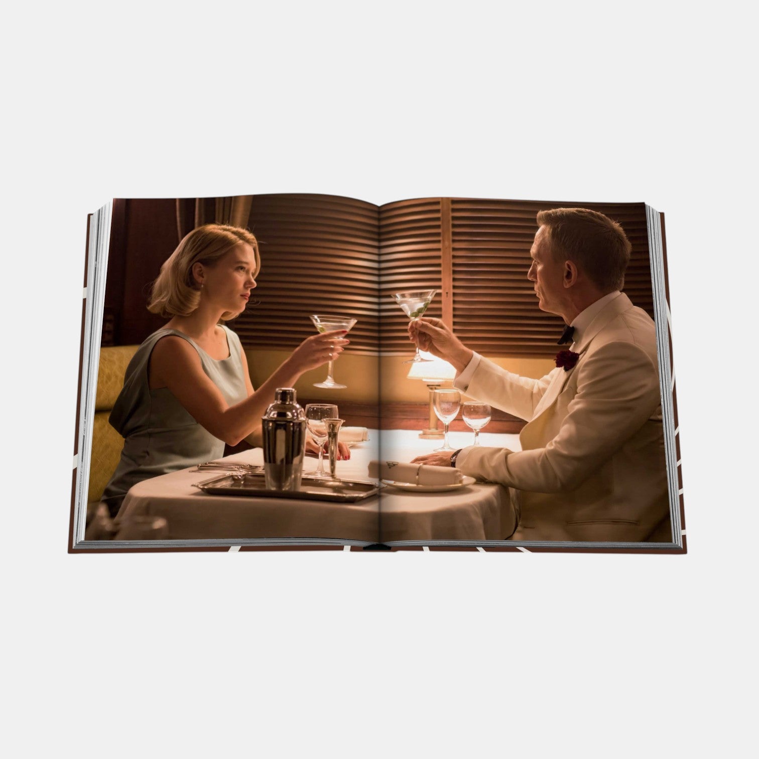 Shop Rescue Spa James Bond Style hardcover book open to a scene of Daniel Craig and Lea Seydoux dining together.