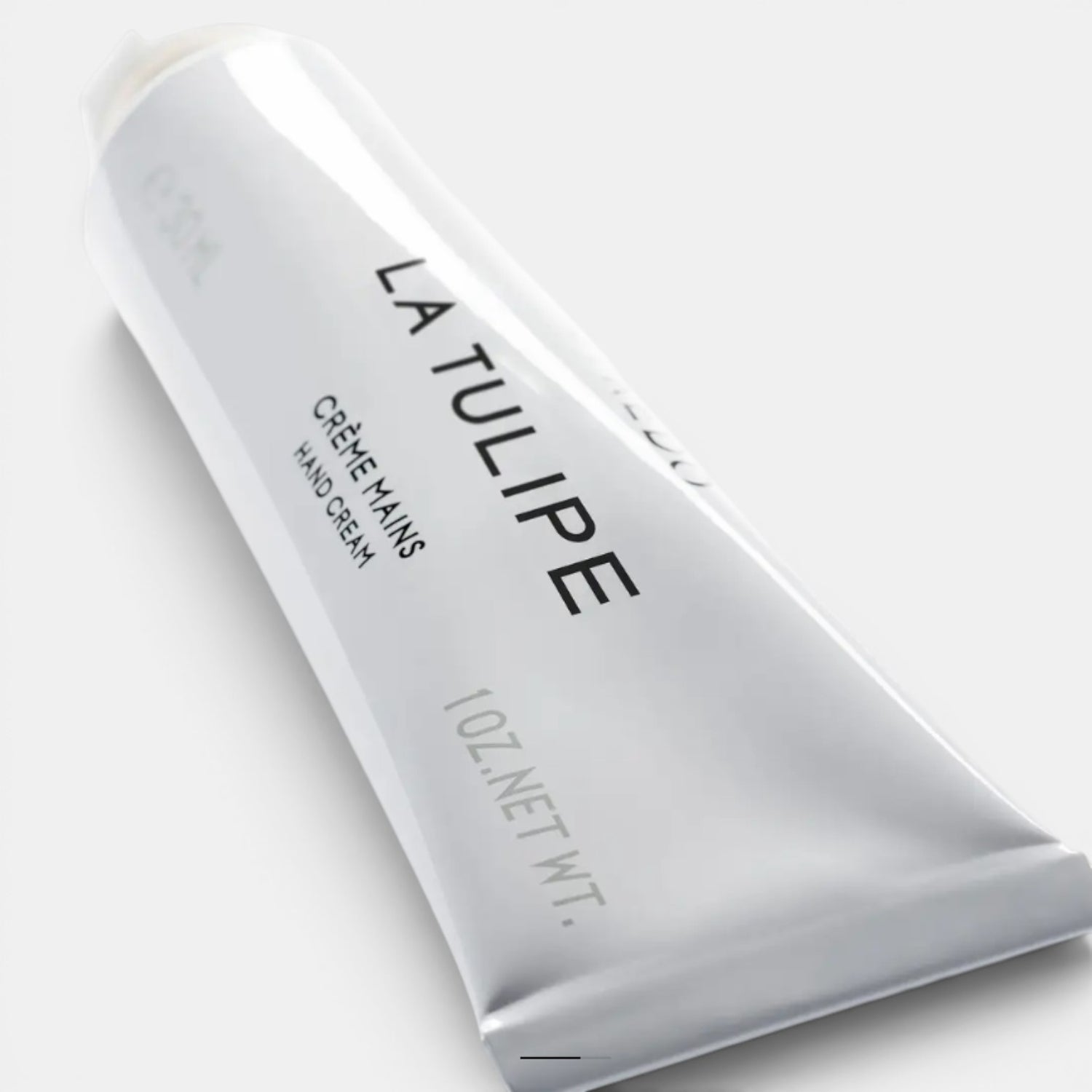 Shop Rescue Spa La Tulipe hand cream in a travel-sized silver tube with black text. Scent notes include tulip, cyclamen, freesia, rhubarb, and blonde woods.