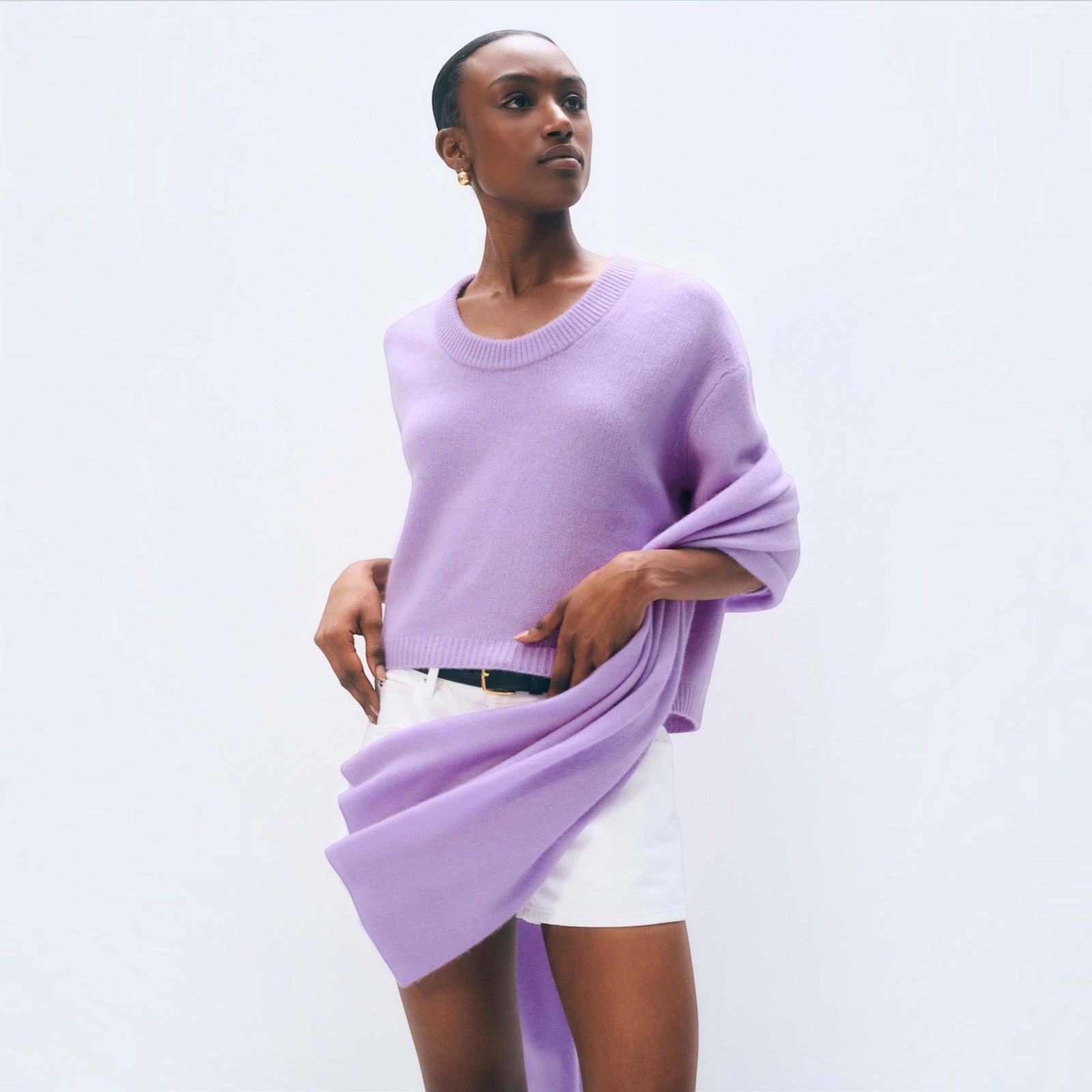 Shop Rescue Spa lavender fog cashmere travel wrap draped over a model wearing a matching sweater and white shorts
