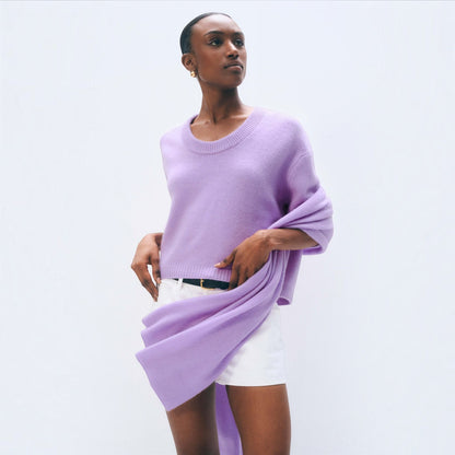 Shop Rescue Spa lavender fog cashmere travel wrap draped over a model wearing a matching sweater and white shorts