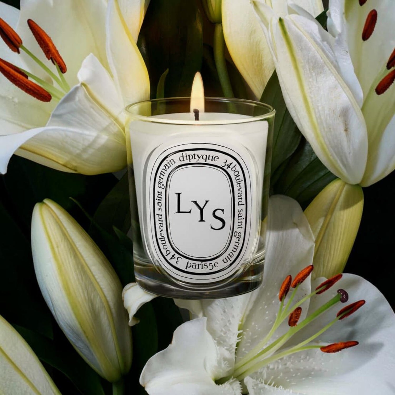 Shop Rescue Spa Lys scented candle in a glass vessel surrounded by fresh white lily flowers