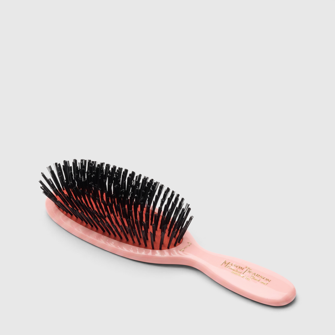Shop Rescue Spa Mason Pearson pocket child hairbrush with a pink cellulose acetate handle and black boar bristles.