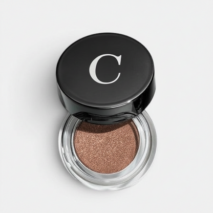 Shop Rescue Spa Mermaid Eye Matte eyeshadow in a bronze shade with a velvet finish in a glass pot with black lid.