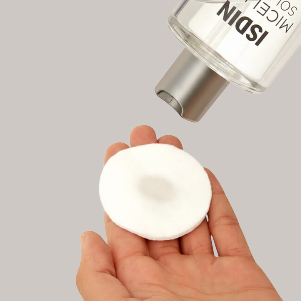 Shop Rescue Spa 4-in-1 micellar solution being poured onto a soft white cotton pad for gentle facial cleansing