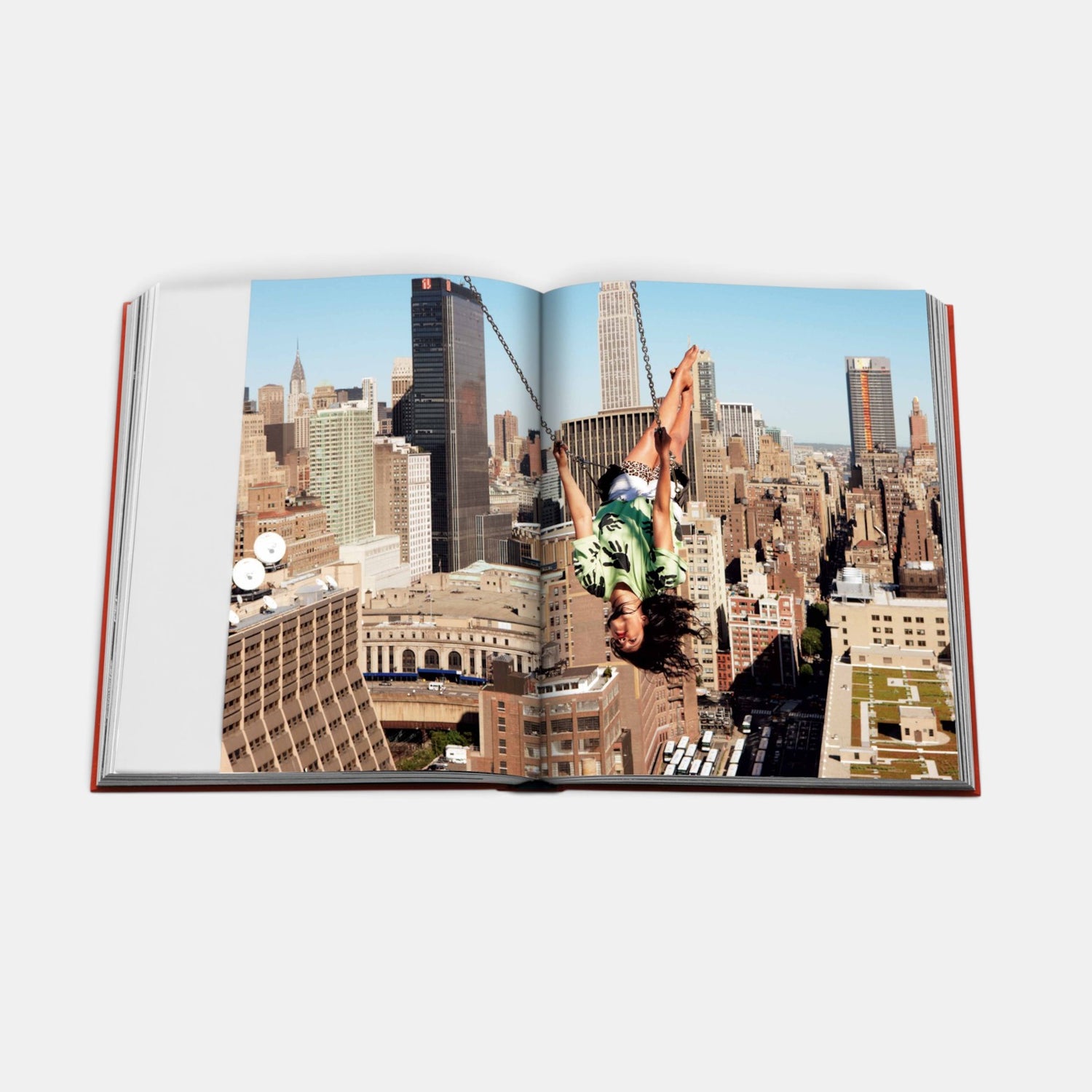 Shop Rescue Spa New York by New York hardcover book open to a page showing a person swinging above the city skyline