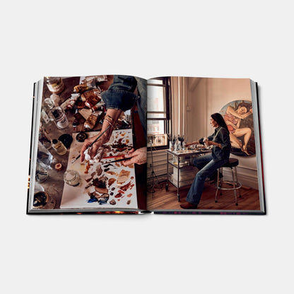 Shop Rescue Spa New York Chic book open to a page showing an artist painting in a studio with art supplies