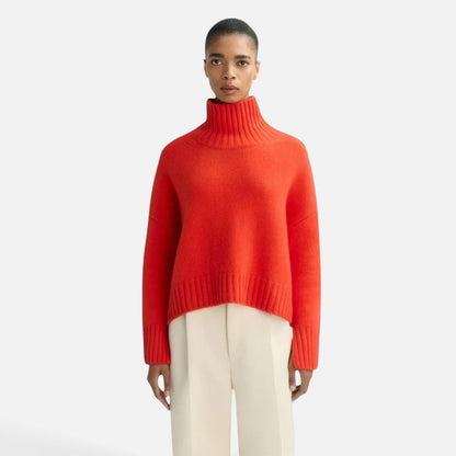 Shop Rescue Spa Girlfriend turtleneck sweater in bright orange chunky cashmere with sleeve slits on a model