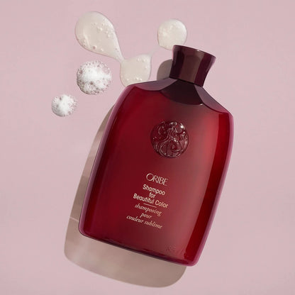 Shop Rescue Spa Oribe Shampoo for Beautiful Color in a deep red bottle with white lather bubbles on a pink background