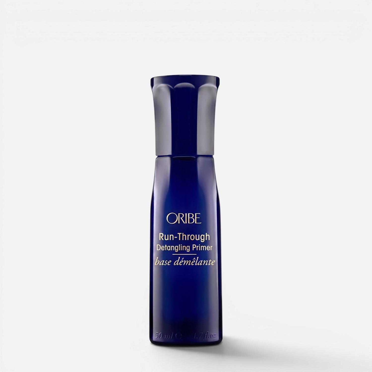 Shop Rescue Spa Oribe Run-Through Detangling Primer in a 1.7 oz dark blue travel-size bottle.